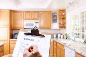 hand writing in a file with the word Estimate, inspecting the kitchen