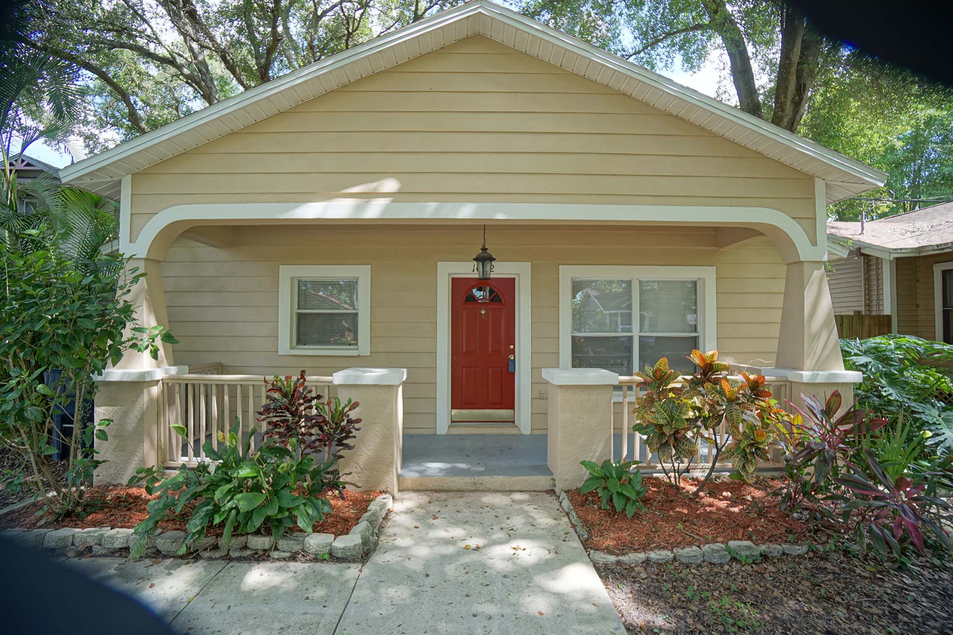A beige house with a red door near where Hoffman Realty offers Tampa real estate services