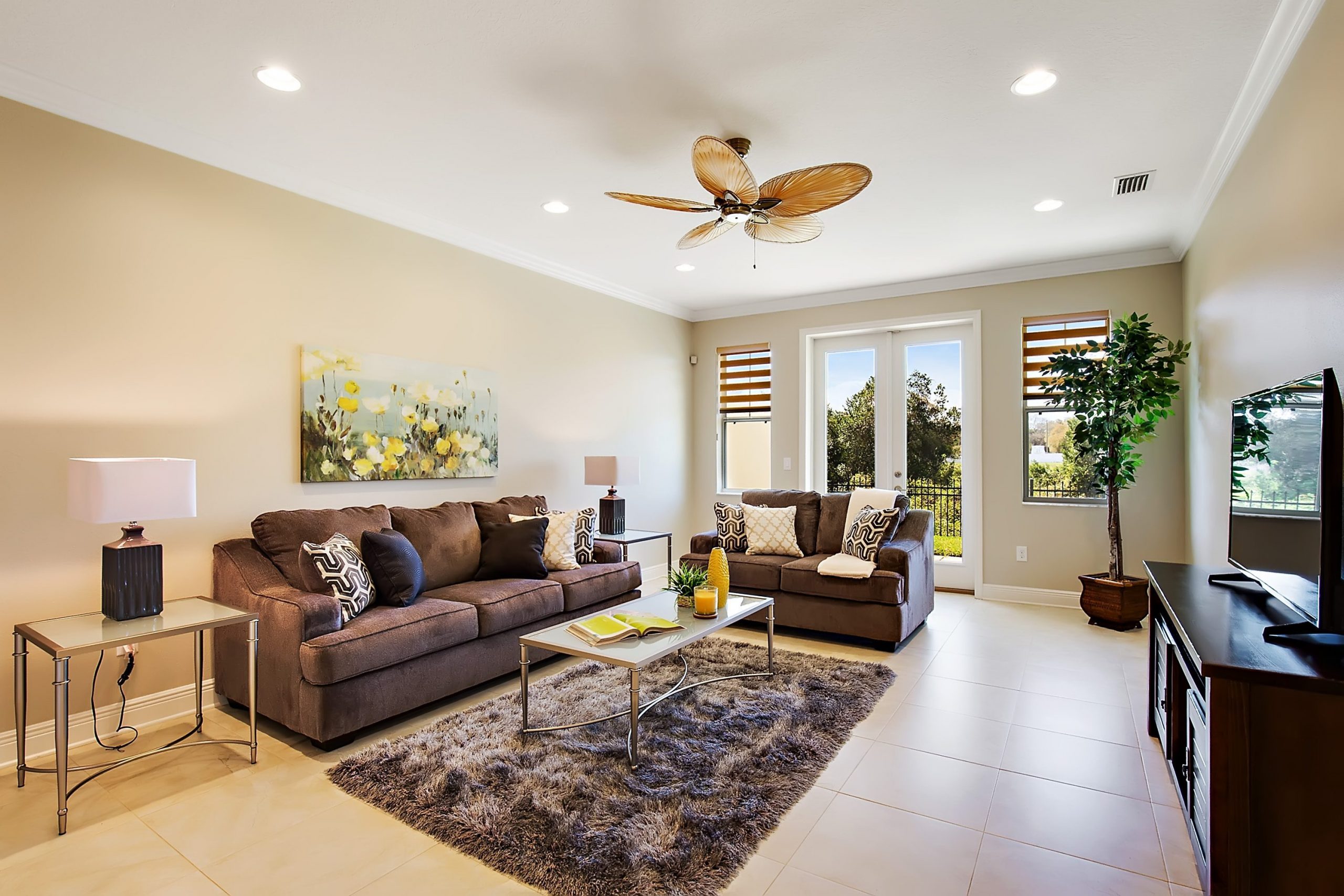 A well-lit living room with two brown couches and a brown rug and coffee table, near where Hoffman Realty provides Tampa real estate services