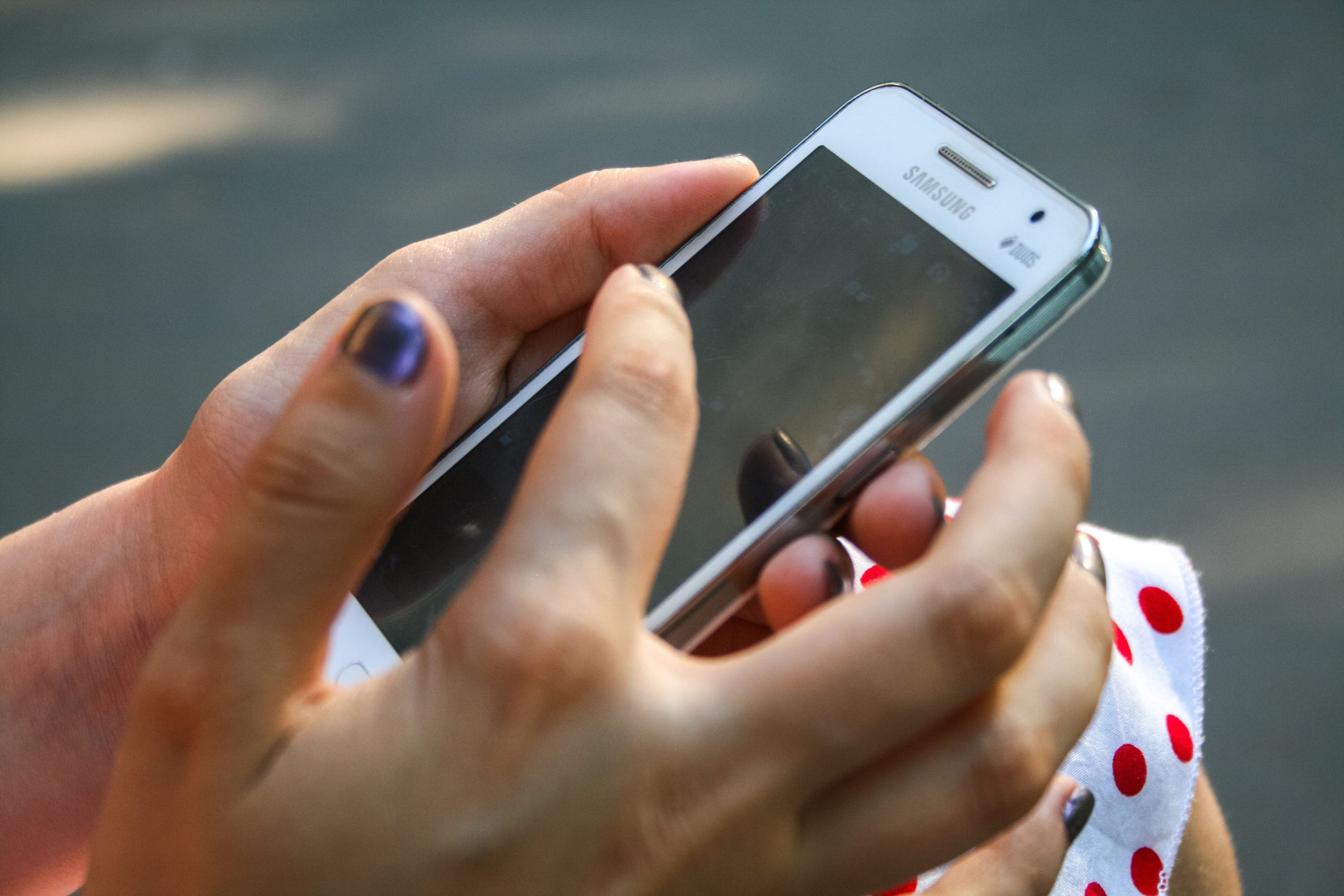 a man's hand holding an android phone to ensure you bookmark Hoffman Realty Facebook Page