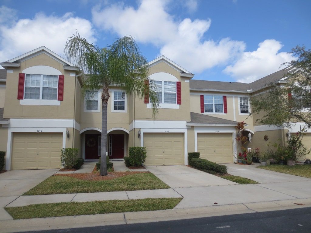 A beige two-story home with a pool and double staircase near where you can hire a Tampa property manager from Hoffman Realty