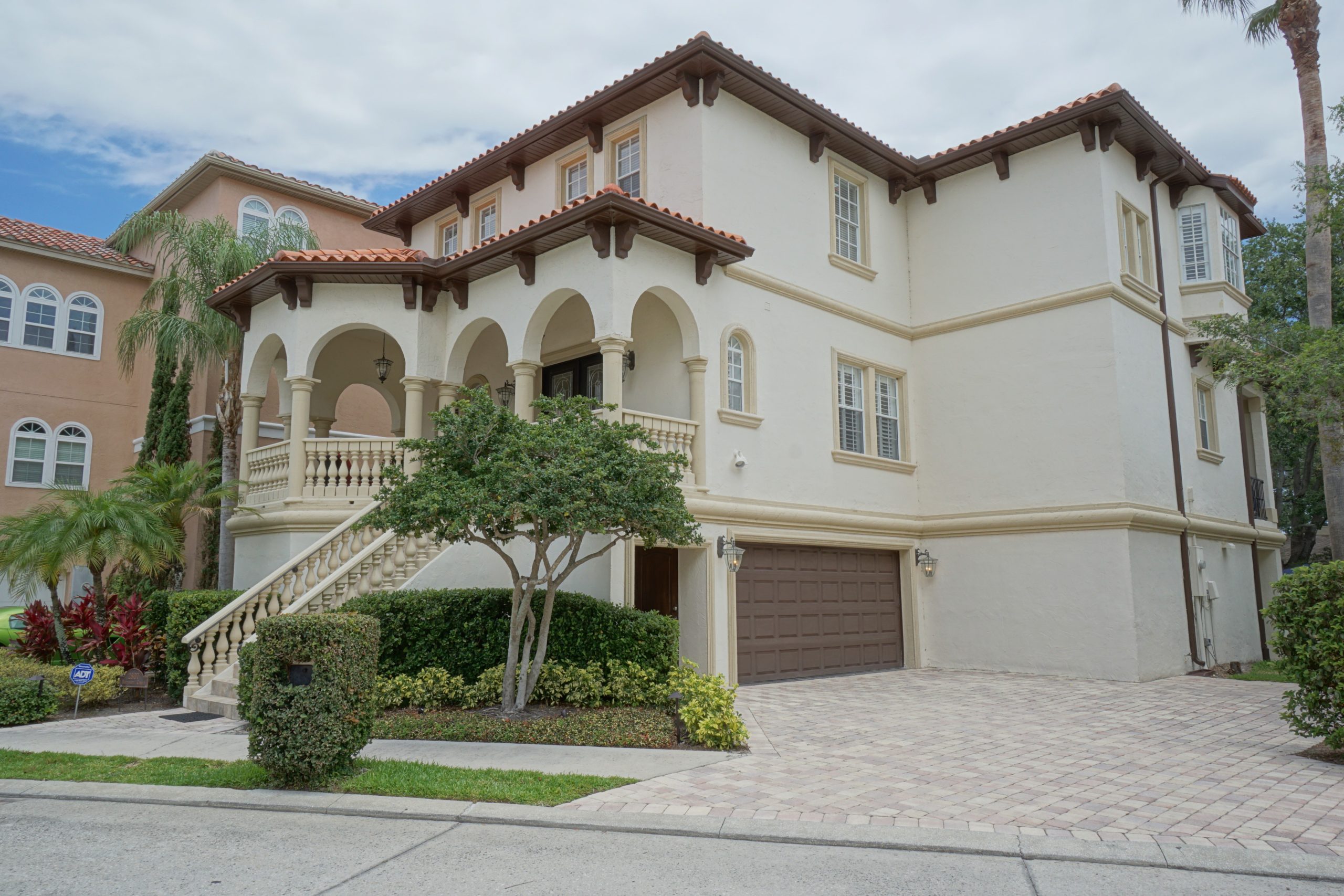 Tampa big beige mansion house with front stairs and garage