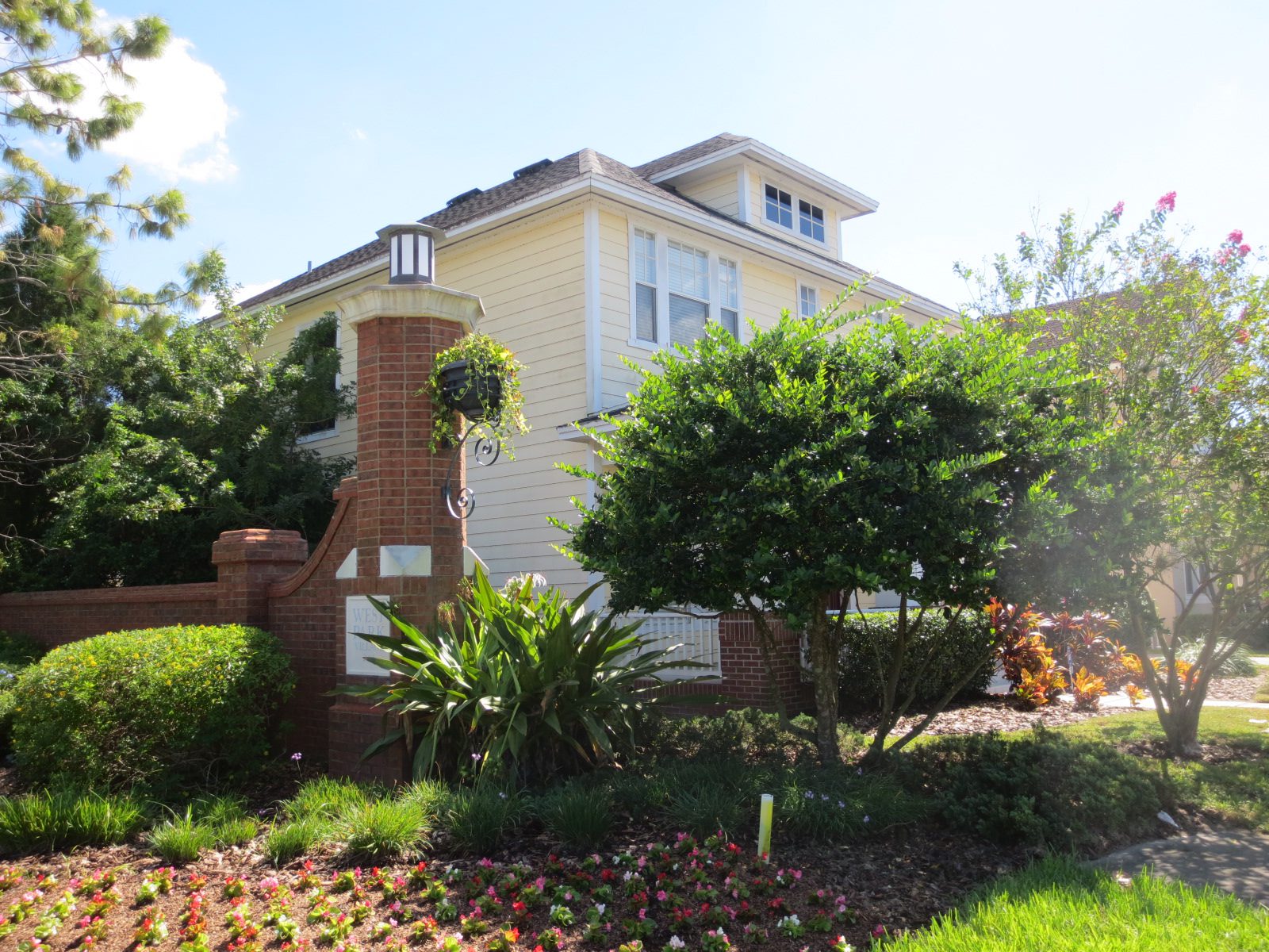 Several beige townhomes with white trim and red shutters, near where you can hire a Tampa property manager from Hoffman Realty