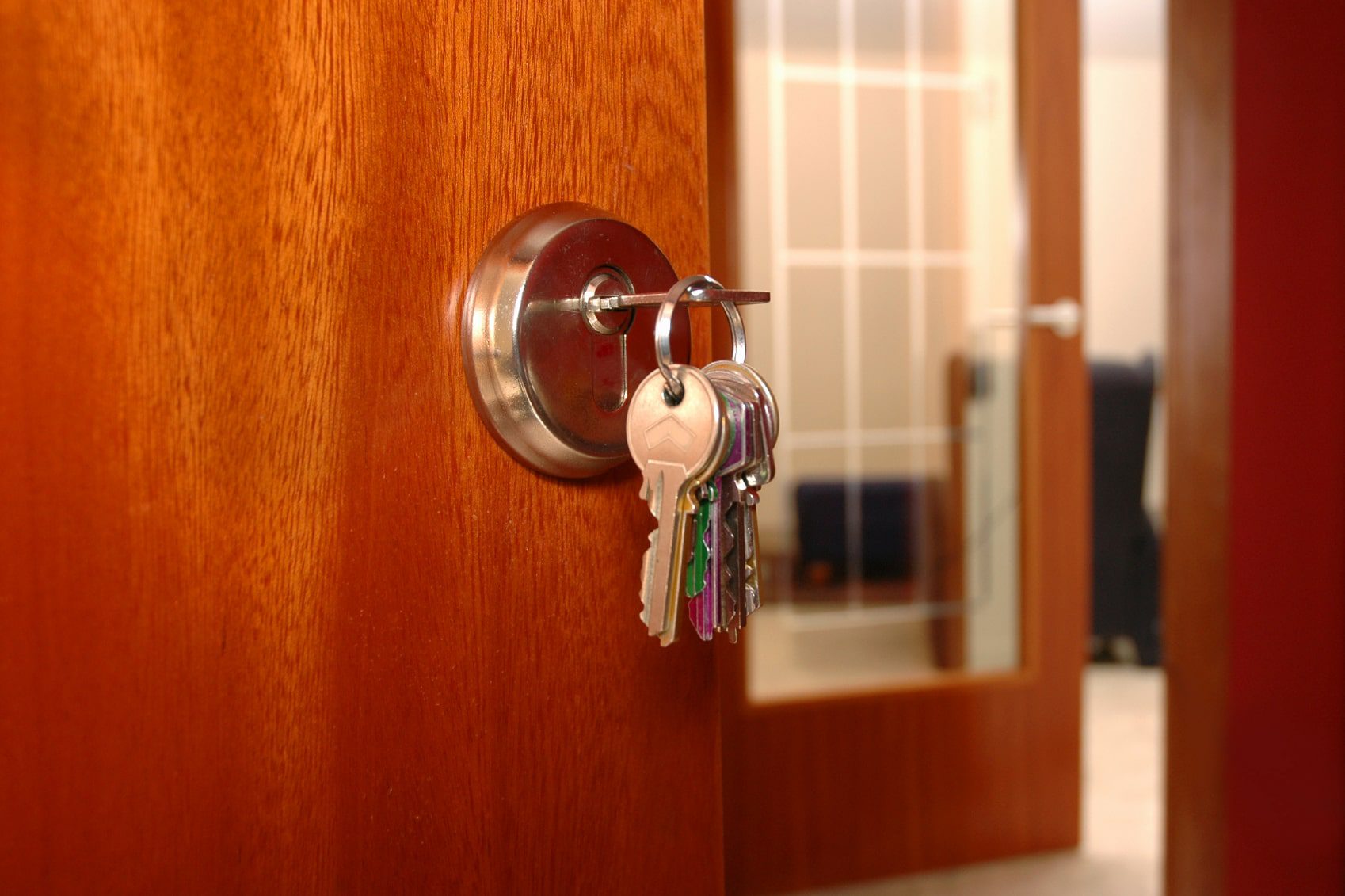 When you rent a home with Hoffman realty, you might have a home like this one, with a cherry-colored wood door with the keys hanging in the lock, 